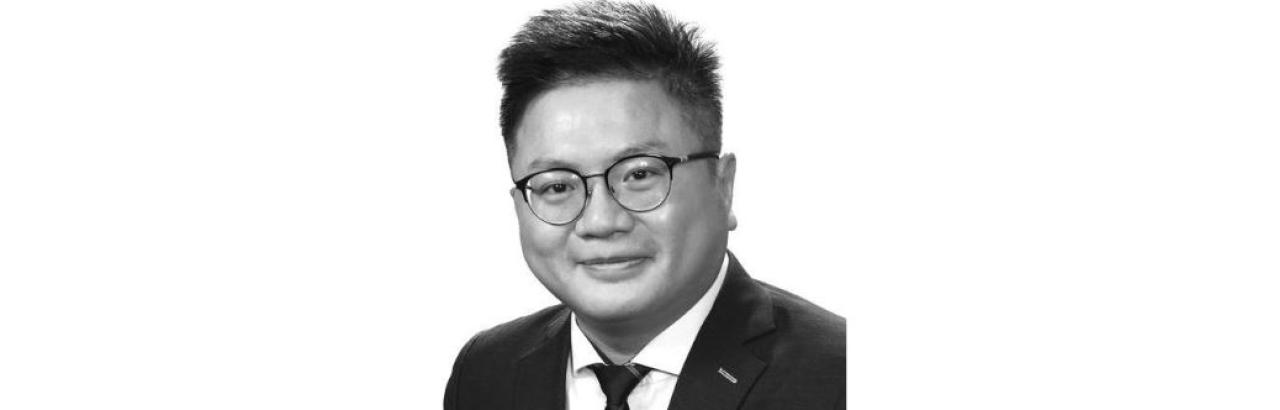 Chinese man with black hair and glasses wearing a suit