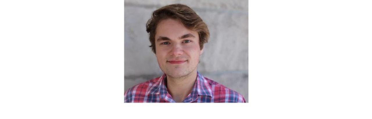 photo of Ross Kaine, a young white man with brown short hair wearing a blue and pink plaid shirt