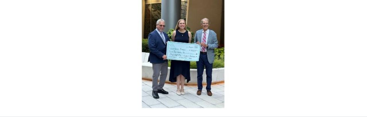 Emily Dinelli receives a large check for her scholarship