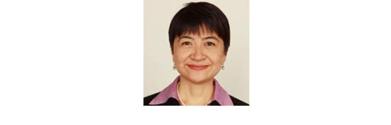 Color photo of Cindy Cai, a middle aged Chinese woman with short black hair wearing a pink blouse under a black blazer