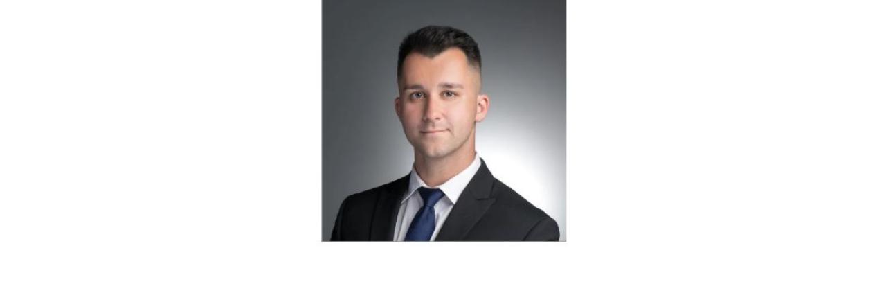 photo of Robert Cotter, a young white man with brown hair wearing a suit and tie