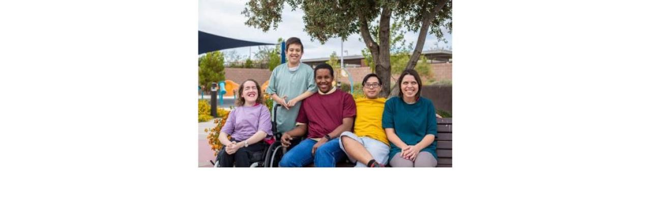 color photo of several people gathered on a park bench