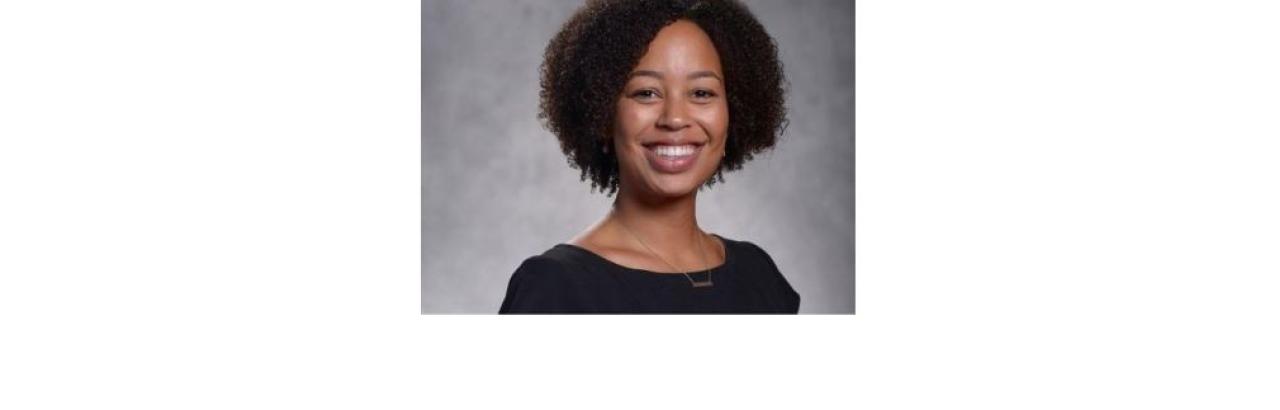 color photo of diminique kinnet hopkins, a young Black woman with short curly black hair and a black top