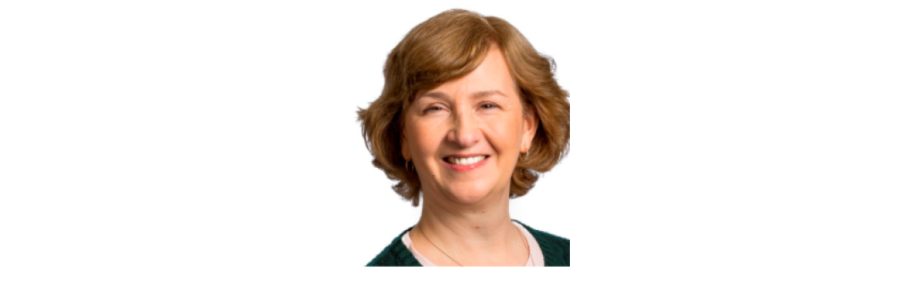 color photo of Anne Deutsch, a middle aged white woman with short blonde hair wearing a black top.