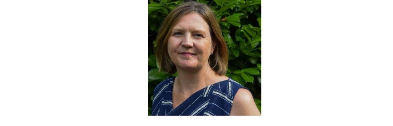 color photo of Jane Duff, a middle aged white woman with short brown hair wearing a flowered blue tank top