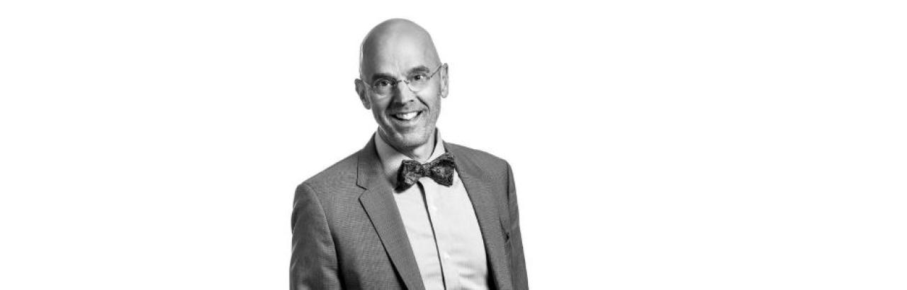 photo of Allen Heinemann, an white mad with glasses wearing a grey suit and bowtie