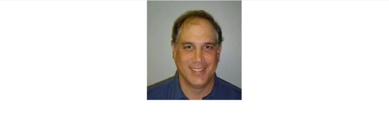 Color photo of Eric Lipp, a middle aged white man wearing a grey shirt