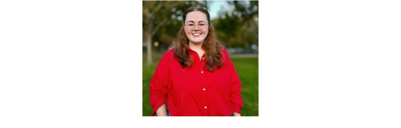 color photo of Hope Sparks, a young white woman with brown shoulder-length hair and glasses wearing a red button down shirt