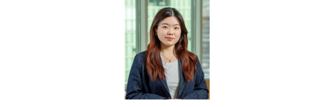 color photo of Weiwei Li, a young Chinese student with long brown hair wearing a gray t shirt and denim blazer