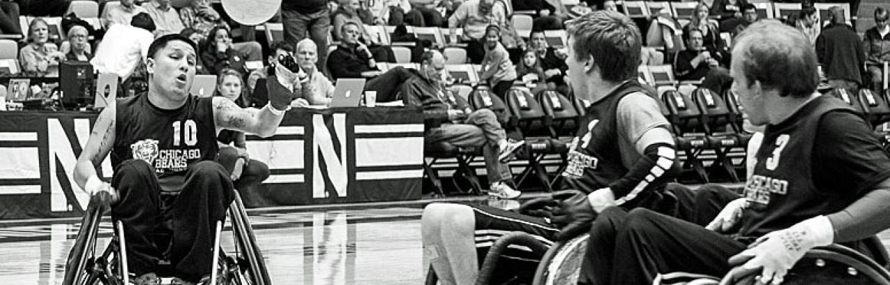 Wheelchair Rugby match. Athlete goes after ball in the air.