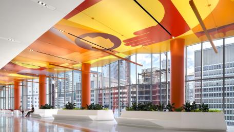 the Sky Lobby of Shirley Ryan AbilityLab. Orange ceiling, white floors with planters and large windows