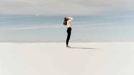 woman with face in hands in desert