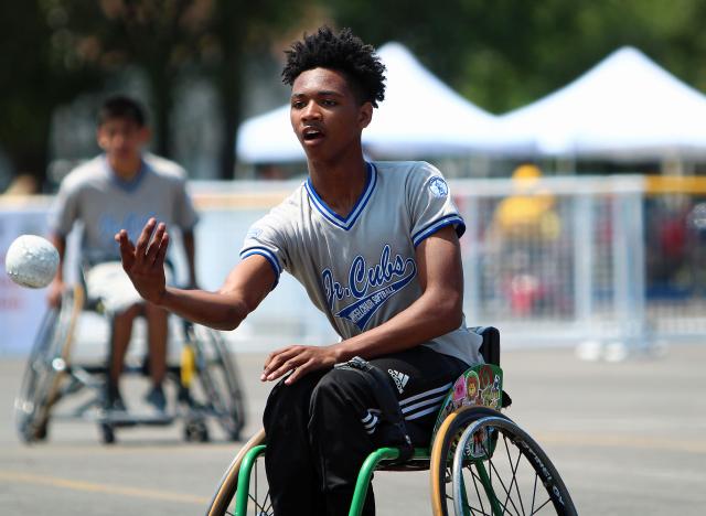 Junior wheelchair softball player pitching ball
