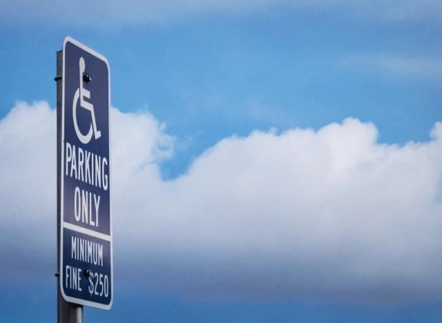 Parking sign against blue sky with clouds
