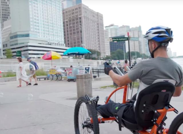 Brad the Bullet Baker riding a hand cycle on a beach in chicago