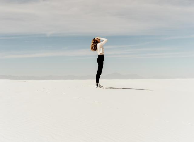 woman with face in hands in desert