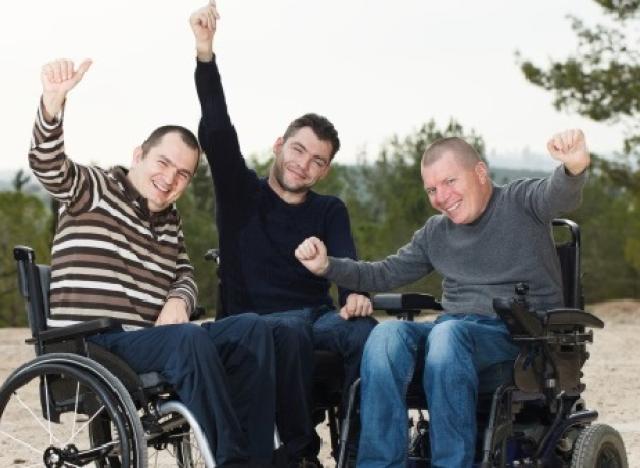 three happy men in wheelchairs