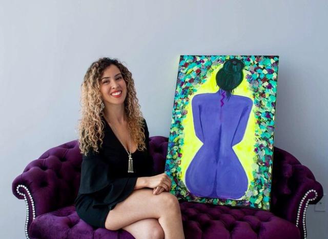 Genevieve in her studio with one of her paintings