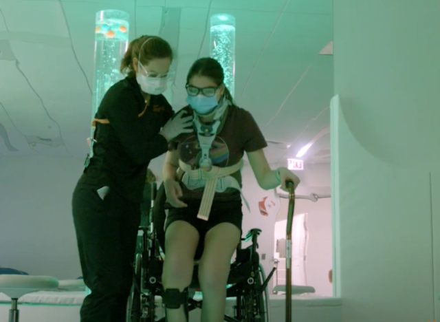 Care team member helping patient out of wheelchair