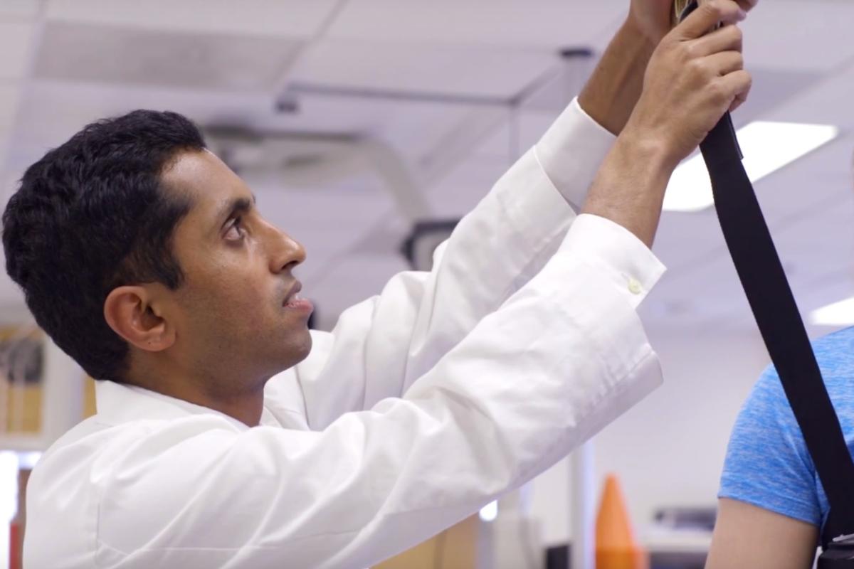 Prakash Jayabalan helps a concussion patient on a gait track