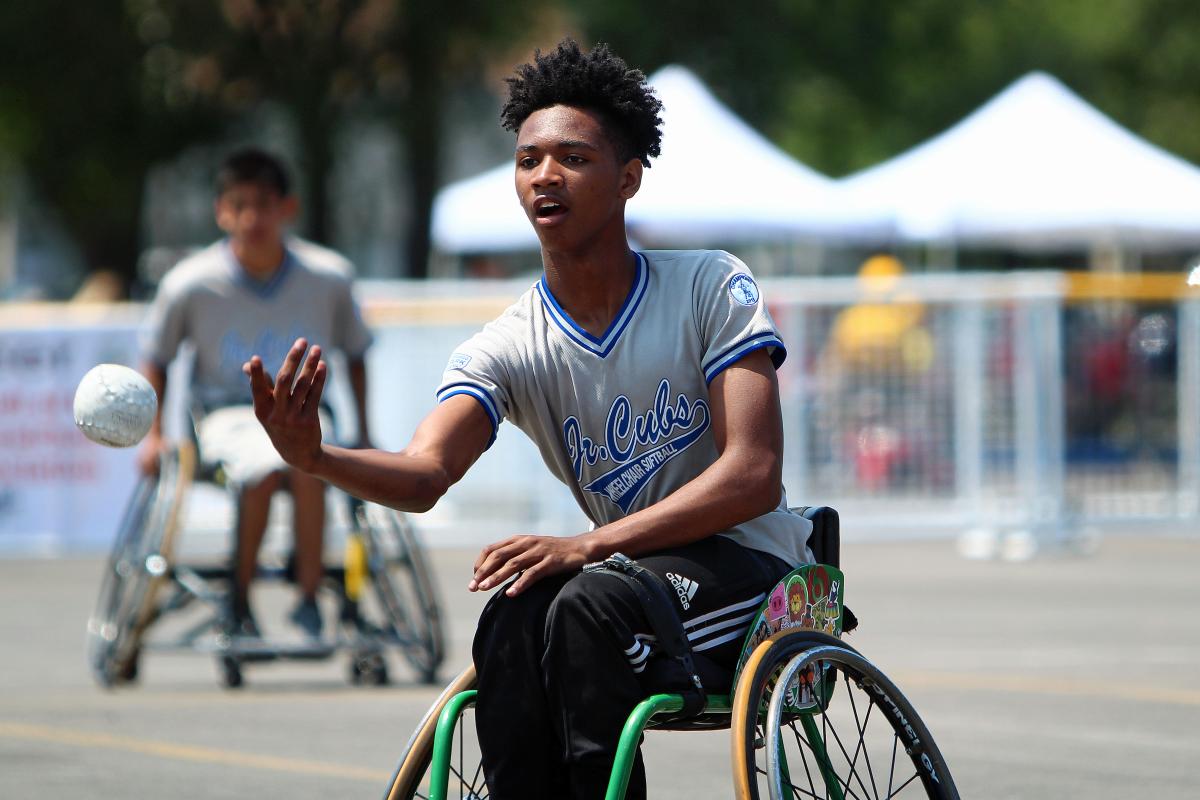 Junior wheelchair softball player pitching ball