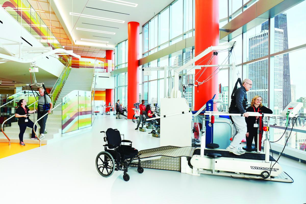 A physical therapist at the Shirley Ryan AbilityLab leads gait training for a patient. The patient’s weight is shared with the lift system, which decreases support as the patient’s ability increases.