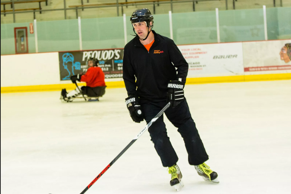 derek Daniels playing hockey with the adaptive hockey team