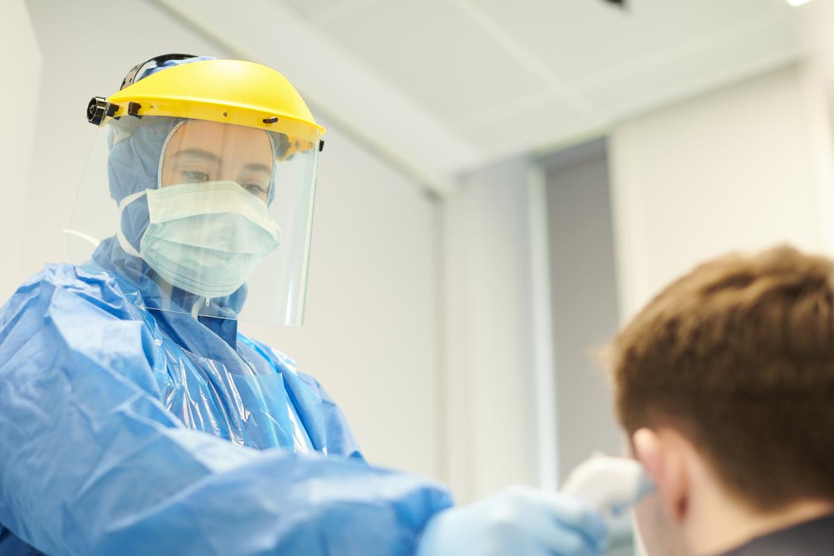 Doctor in PPE taking care of patient