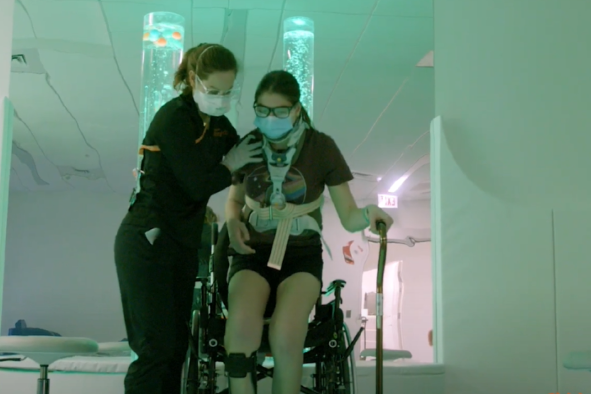 Care team member helping patient out of wheelchair