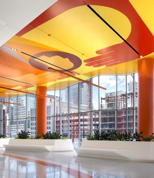 the Sky Lobby of Shirley Ryan AbilityLab. Orange ceiling, white floors with planters and large windows
