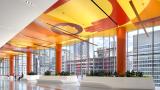 the Sky Lobby of Shirley Ryan AbilityLab. Orange ceiling, white floors with planters and large windows