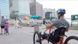 Brad the Bullet Baker riding a hand cycle on a beach in chicago
