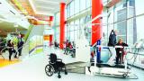 A physical therapist at the Shirley Ryan AbilityLab leads gait training for a patient. The patient’s weight is shared with the lift system, which decreases support as the patient’s ability increases.