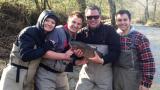 Scott and family in fishing gear holding a fish
