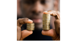 black man holding two stacks of coins in his hands