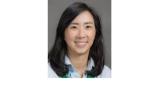 Color photo of Danbi Lee, a young Asian woman with shoulder length black hair wearing a light blue button down shirt