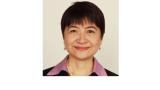 Color photo of Cindy Cai, a middle aged Chinese woman with short black hair wearing a pink blouse under a black blazer