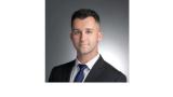 photo of Robert Cotter, a young white man with brown hair wearing a suit and tie