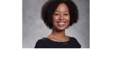 color photo of diminique kinnet hopkins, a young Black woman with short curly black hair and a black top